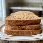 ['Close-up side view of soft whole wheat sandwich bread, showcasing its texture and crust.', 'Detailed shot of freshly baked whole wheat sandwich bread with a golden-brown crust.', 'Soft whole wheat sandwich bread displayed from the side, highlighting its fluffy interior.', 'Rustic view of whole wheat sandwich bread, emphasizing its wholesome ingredients and softness.']