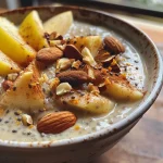 ['Close-up view of a creamy apple cinnamon chia pudding with apple slices on top.', 'Side view of a jar filled with apple cinnamon chia pudding garnished with almonds and cinnamon.', 'Rich chia pudding featuring layers of apple and cinnamon, served in a glass container.', 'Detailed image of apple cinnamon chia pudding showing layers and toppings of chopped apples and almond slices.']