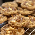 ['Close-up of caramel apple cookies with a glossy caramel drizzle.', 'Side view of freshly baked caramel apple cookies displaying chunks of caramel.', 'Detailed image of soft caramel apple cookies with a golden-brown color.', 'Appetizing close-up of cookies infused with spiced apple cider and caramel.']