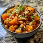 ['Close-up view of warm-spiced chickpea and sweet potato stew garnished with parsley and almonds.', 'Side view of a bowl filled with chickpea and sweet potato stew, showcasing chunks of sweet potatoes and apricots.', 'A vibrant bowl of chickpea stew with sweet potato, apricots, and fresh herbs, highlighting its rich colors.', 'Detailed image of a hearty chickpea and sweet potato stew with almonds and parsley on top.']