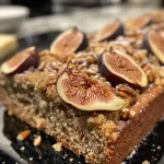 ['Close up of freshly baked fig bread with a golden crust and visible fig pieces.', 'Side view of a slice of fig bread showcasing its moist texture and nuts.', 'Detailed image of a fig bread loaf revealing chunks of figs and spices in the batter.', 'A perfect slice of fig bread with a rich, inviting brown color and a sprinkle of walnuts on top.']