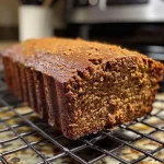 ['Close-up view of a moist gingerbread loaf with a golden-brown crust.', 'Side angle of a delicious gingerbread loaf, showcasing its fluffy texture and glaze.', 'Juicy slice of gingerbread loaf with a rich, aromatic spice blend on display.', 'Appetizing gingerbread loaf highlighted against a rustic wooden background.']