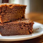 ['Close-up side view of a delicious gingerbread recipe ingredient display.', 'Ingredients for gingerbread laid out, showcasing molasses and spices.', 'Side view of gingerbread ingredients, featuring flour and butter.', 'Detailed shot of a gingerbread recipe with jars of spices and liquids.']