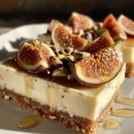 ['Close-up of Honey Fig Cheesecake Bars with sliced figs and pistachios.', 'Side view of creamy cheesecake bars topped with fresh figs and a drizzle of honey.', 'Juicy Honey Fig Cheesecake Bars showcased with a buttery crust and colorful toppings.', 'Delicious cheesecake squares featuring figs, honey, and chopped pistachios.']