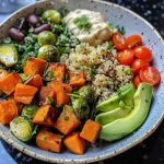 ['Close-up of a vibrant Quinoa Buddha Bowl featuring roasted sweet potatoes, Brussels sprouts, and cauliflower.', 'Side view of a colorful grain bowl filled with quinoa, black beans, and fresh vegetables.', 'Juicy, healthy Buddha Bowl displaying diced avocados, cherry tomatoes, and baby spinach.', 'Detailed image of a flavorful Quinoa Bowl with roasted veggies and a drizzle of hummus.']