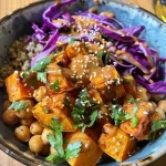 ['A vibrant grain bowl featuring chickpeas and sweet potatoes.', 'Close-up view of a Smoky Tahini Chickpea & Sweet Potato bowl with colorful ingredients.', 'Side view of a grain bowl filled with quinoa, red cabbage, and tahini dressing.', 'Delicious grain bowl showcasing sweet potatoes, chickpeas, and fresh parsley.']