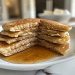 ['Close-up view of golden-brown Snickerdoodle Pancakes stacked on a plate.', 'Side view of fluffy Snickerdoodle Pancakes with a drizzle of syrup.', 'Delicious-looking Snickerdoodle Pancakes topped with cinnamon and sugar.', 'Appetizing Snickerdoodle Pancakes showcasing their soft texture and warm color.']